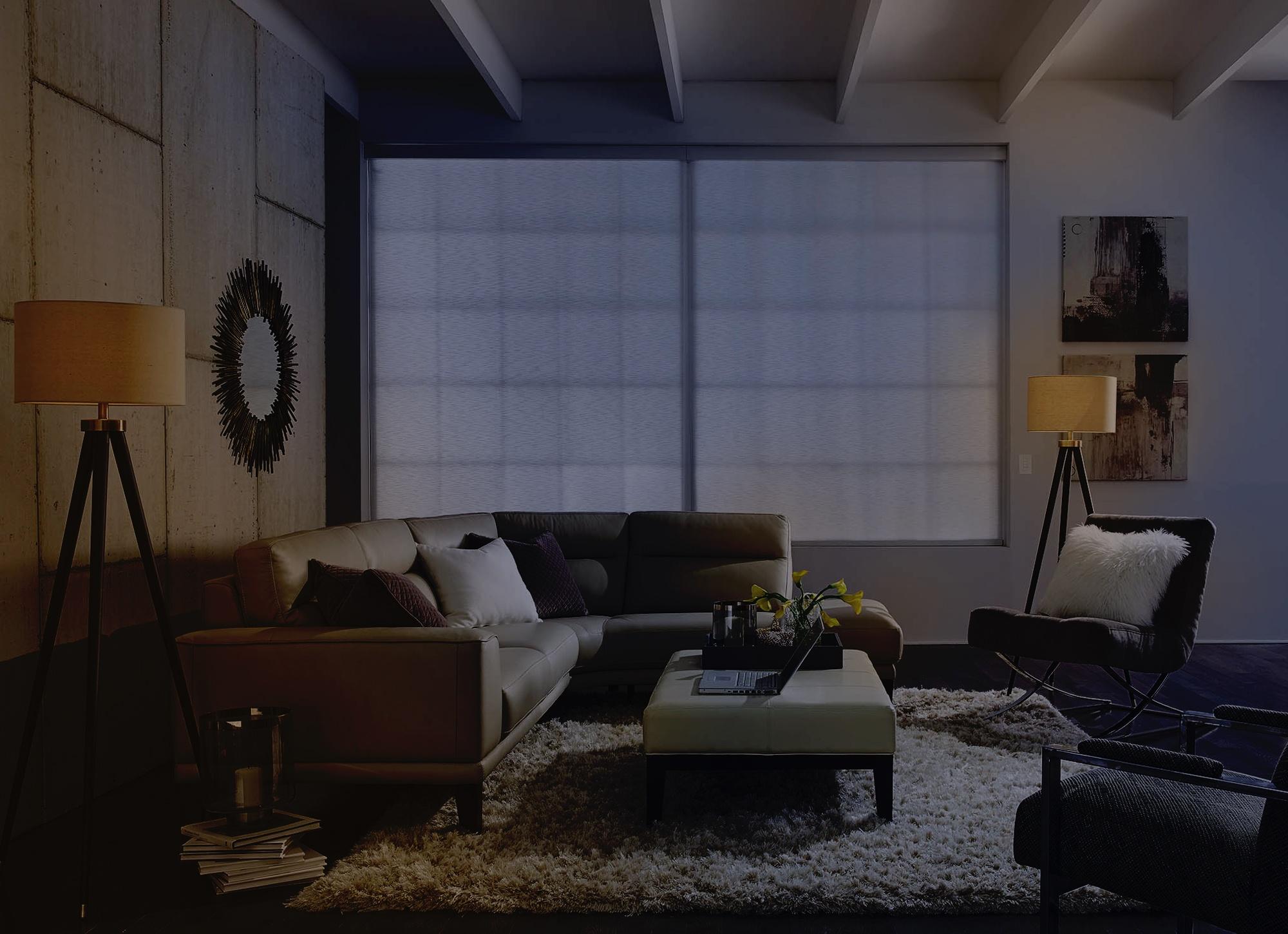 Cozy living room with dim lighting, showcasing a white sectional sofa and a soft, inviting atmosphere.